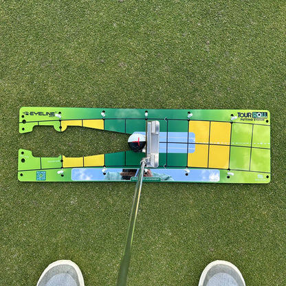Golf putting simulator on a green surface with a golf club in focus.