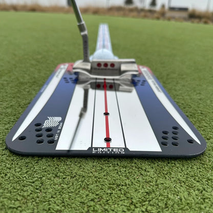 Golf putter with a putter face alignment tool on a green surface